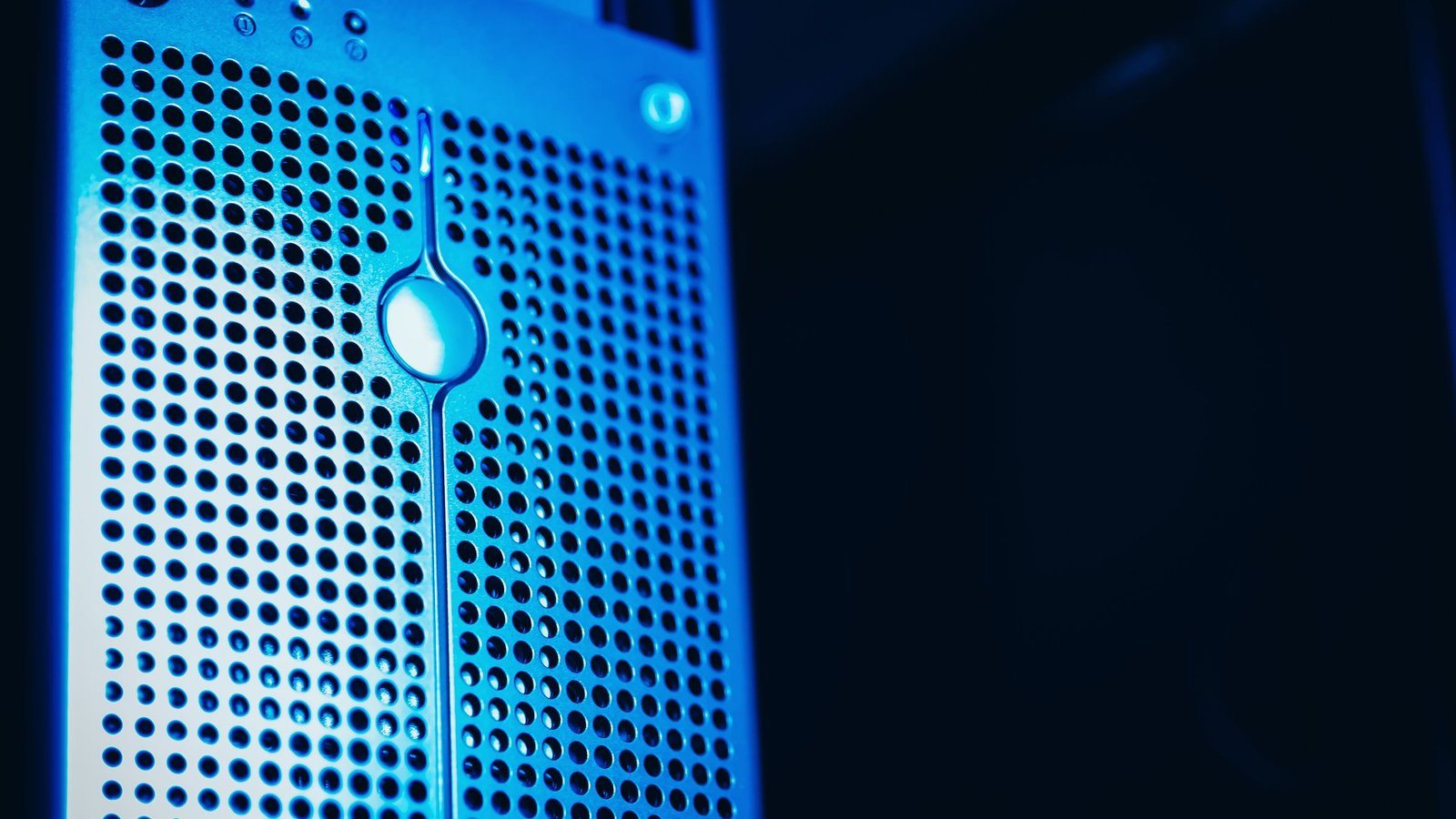 Close-up of a perforated metal server front panel lit in blue against a dark background